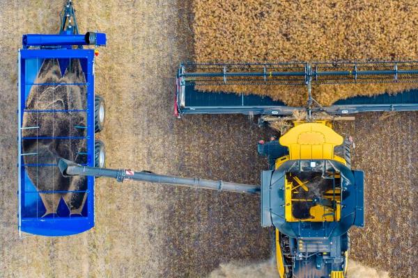 Aerial shot of chaser bin and combine harvesting canola