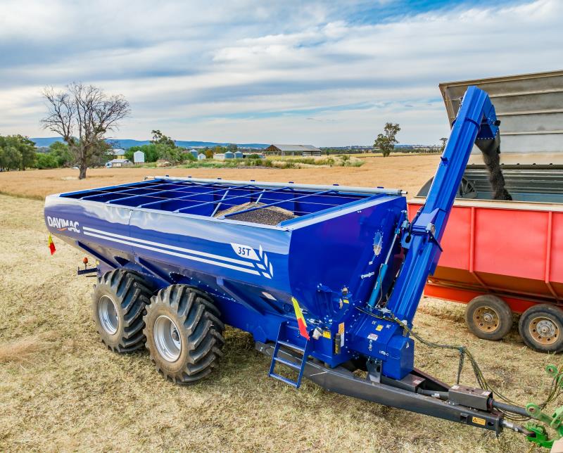 Blue tandem axle chaser bin unloading into mother bin
