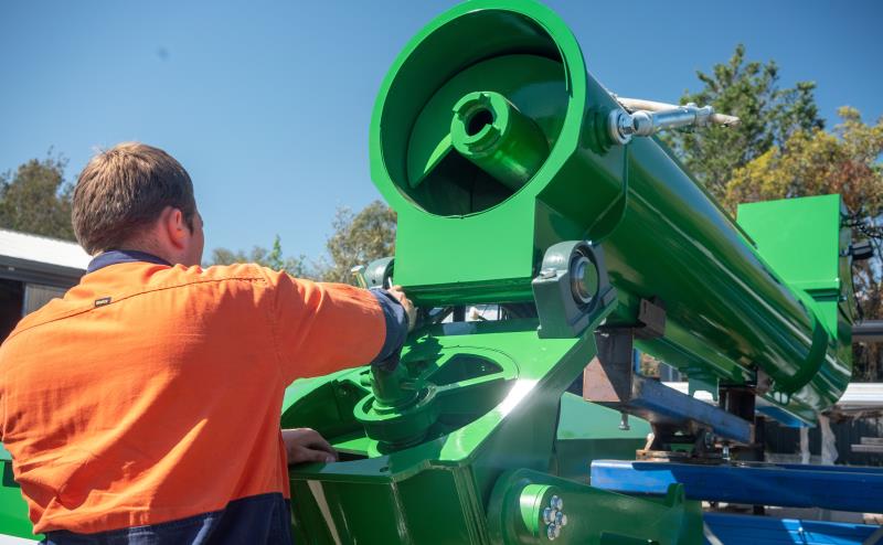 Technician servicing green chaser bin