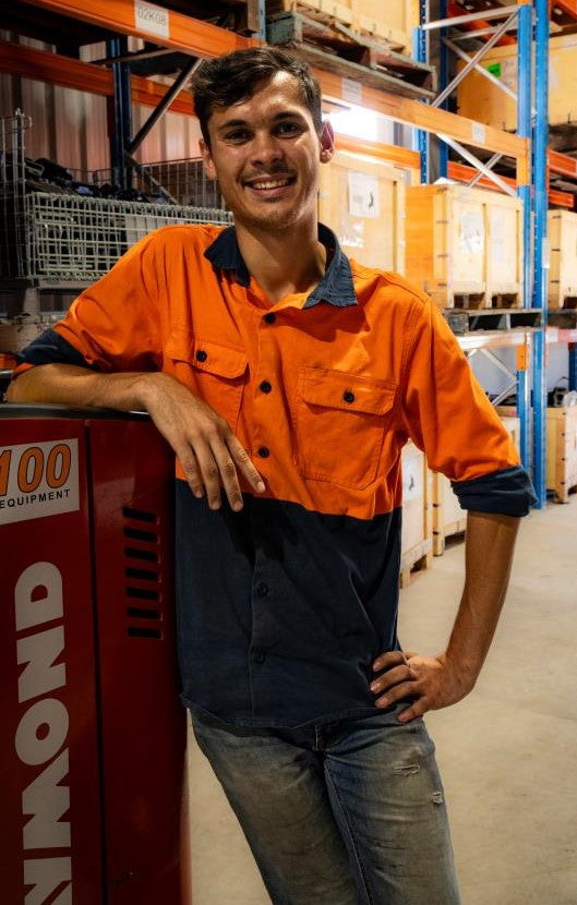 Davimac Spare Parts employee leaning on Forklift in warehouse